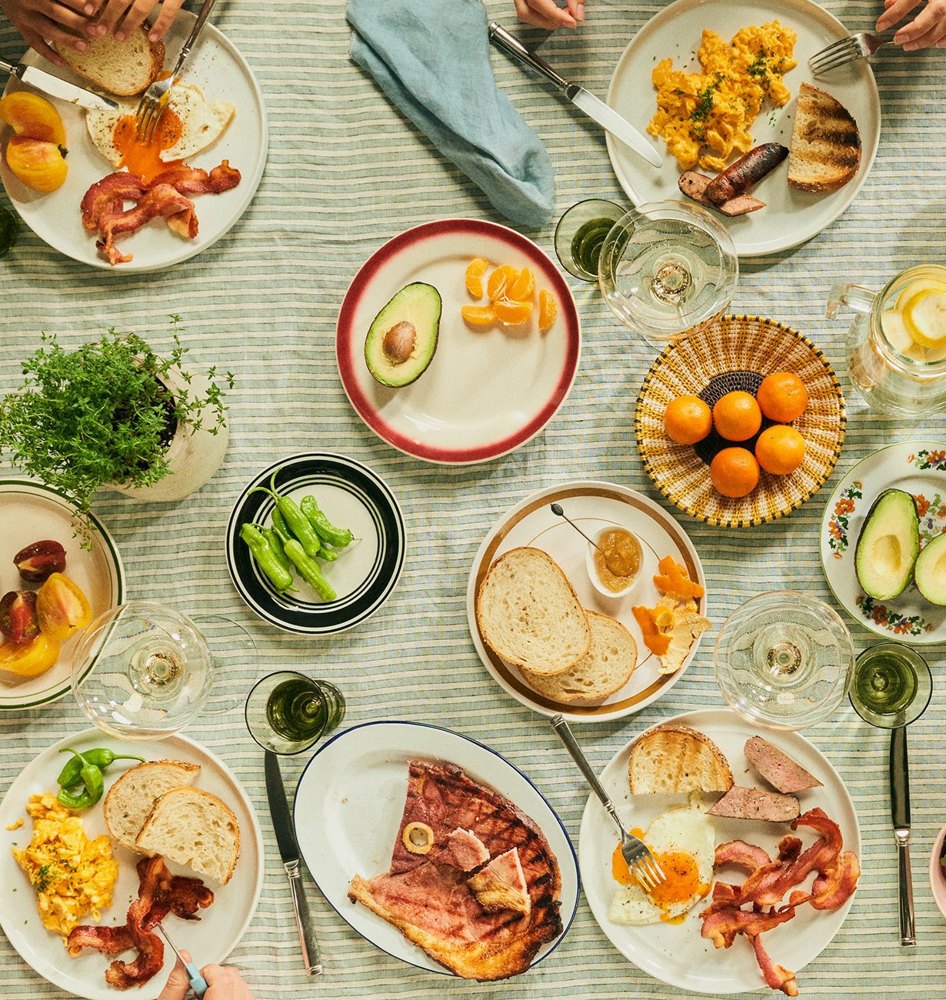 Family breakfast table with Mangalitsa pork, eggs, bread and fruit