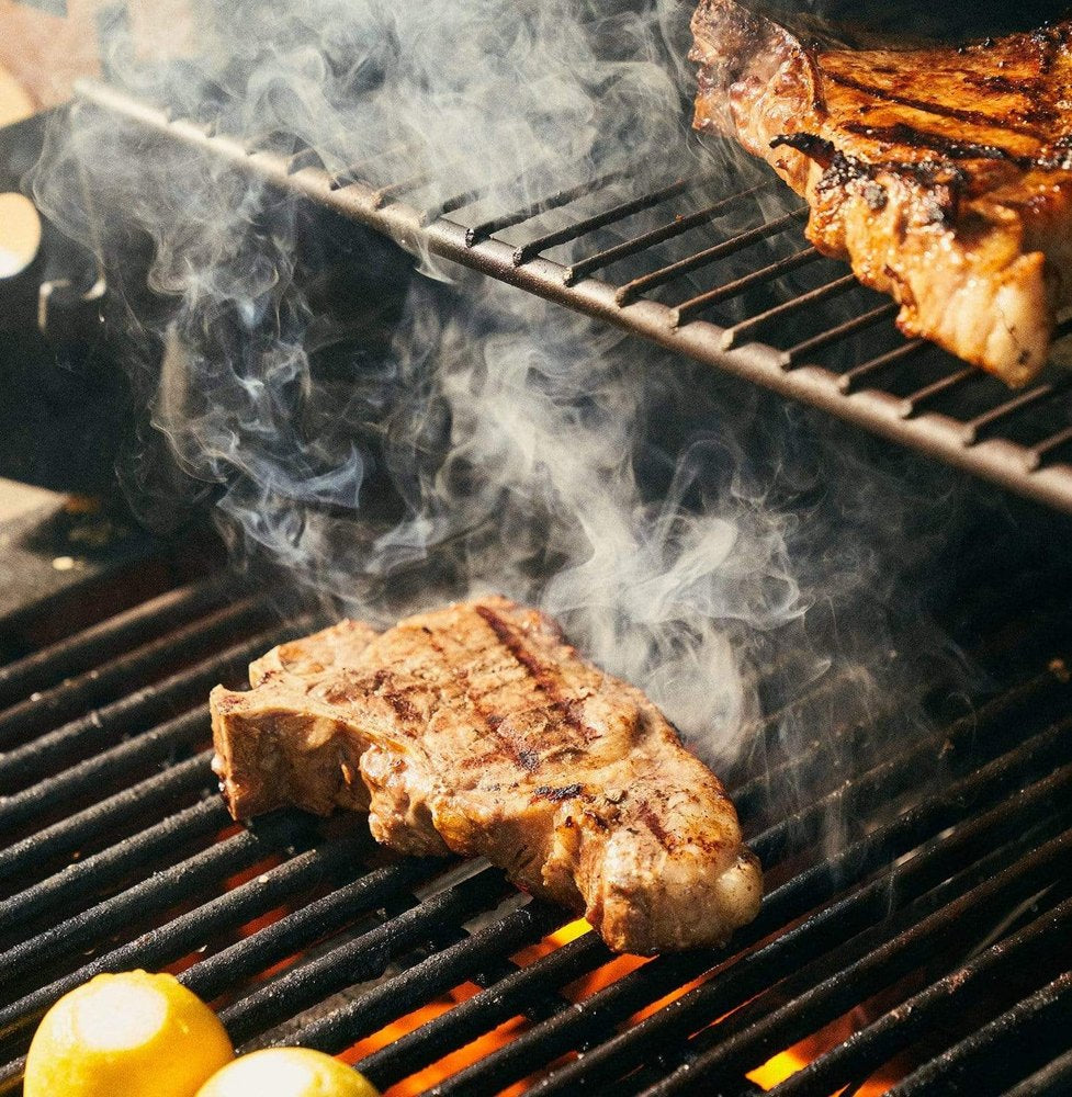 Bone-in pork chops cooking on the grill